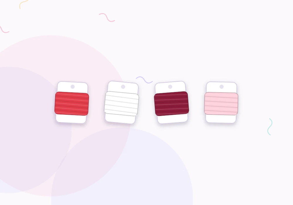 Embroidery floss wound on bobbins in red, white, burgundy and blush