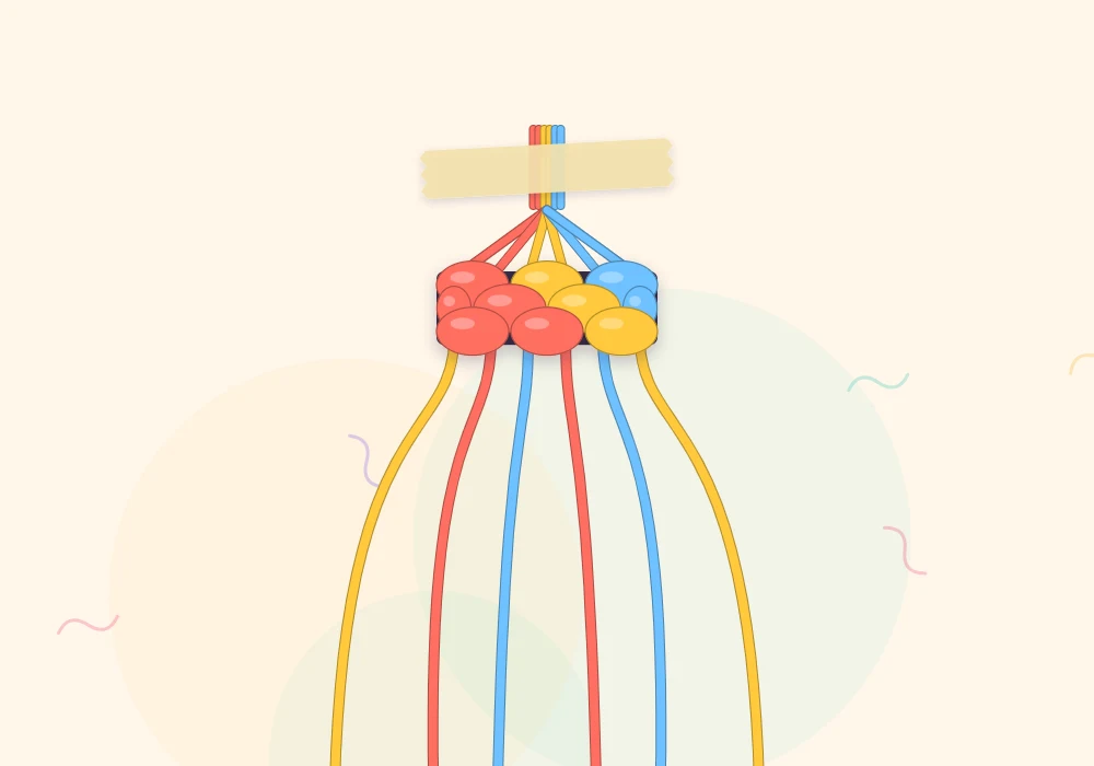 Six strings in coral, sun yellow and sky blue knotted together at the top and taped flat to a work surface