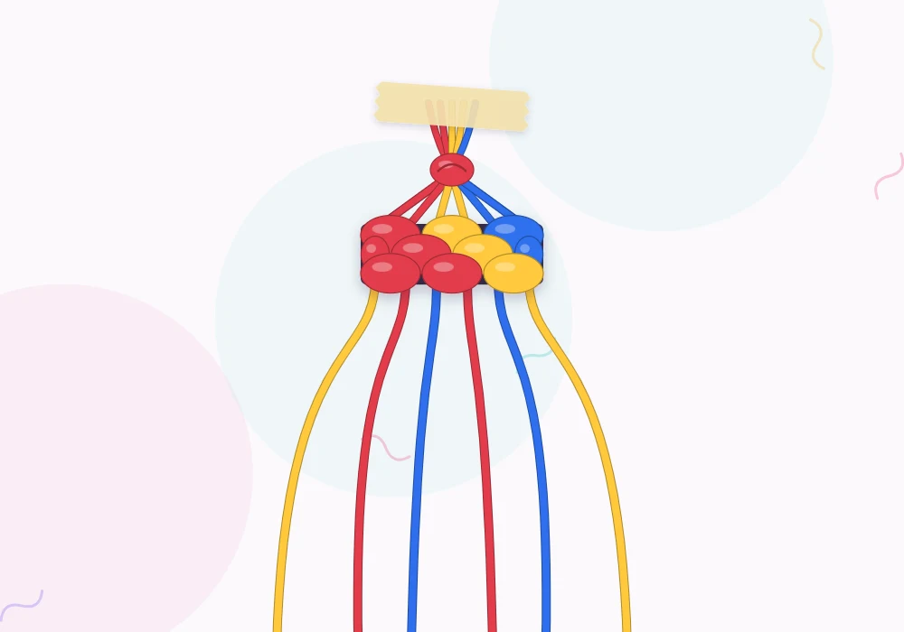 Six strings in red, sun yellow and cobalt tied together with a single overhand knot at the top
