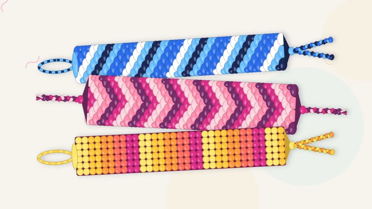 Three finished ombre friendship bracelets stacked, fading through blues, pinks and sunset oranges