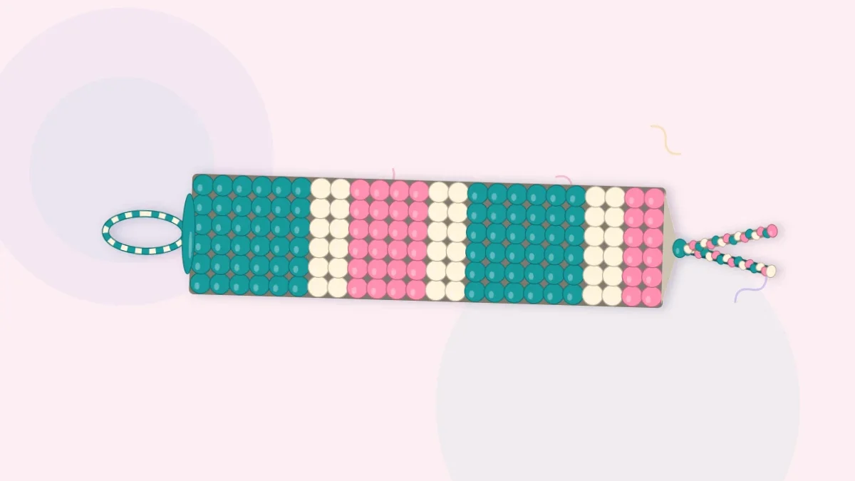 A finished friendship bracelet with straight horizontal bands of teal, cream and rose and navy ties at both ends