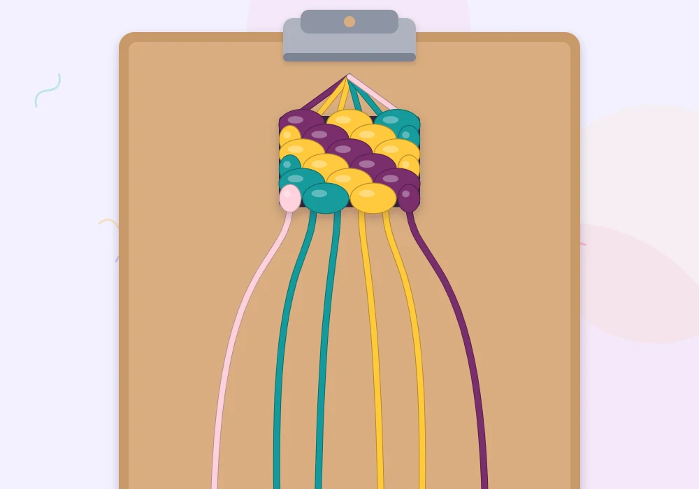 A bracelet in progress held by a clip, with six diagonal rows in plum, sun, teal and blush and loose strings fanned out below
